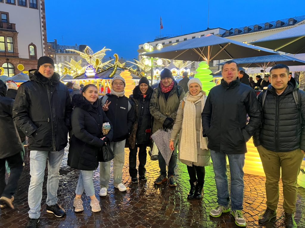 Team octasys im Hintergrund beleuchtet mit Weihnachtsbäumen in verschiedenen Farben