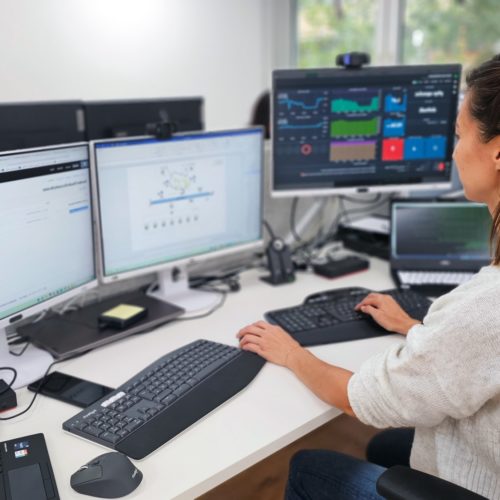 Eine Mitarbeiterin aus der Entwicklung bei Ihrer Arbeit mit 3 Bildschirmen in unserem Büro.