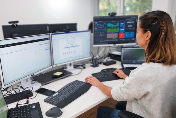 Eine Mitarbeiterin aus der Entwicklung bei Ihrer Arbeit mit 3 Bildschirmen in unserem Büro.